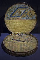 A historical compass decorated with illustrations and tables.