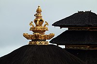 A Balinese kemuncak on top of a thatched roof of a Balinese temple pavilion.