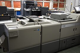 Im Vordergrund eine Linoprint-Digitaldruckmaschine, im Hintergrund ein Heidelberger Offset-Druckwerk.
