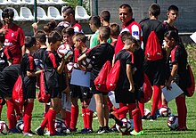 a group of young players in uniform with their coach