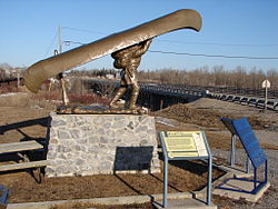 Voyageur statue in Mattice. Bridge over the Missinaibi River is in the background.