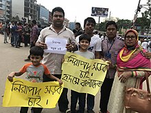 Familie mit Protestplakaten in bengalischer Schrift