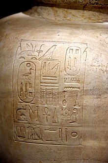 Large round vase of light brown stone inscribed with hieroglyphs