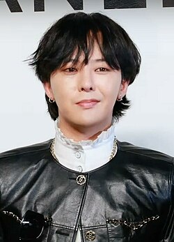 G-Dragon wearing black and white, looking towards the camera