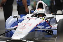 Photograph of Wilson sitting in his blue and white racing car in the pit at the 2015 Indianapolis 500