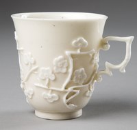 Cup with relief prunus blossom, imitating Chinese styles.