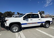 A photograph of a white pickup truck with "Harbor Patrol" written on the side in yellow letters.