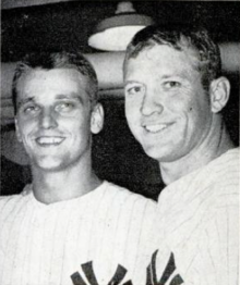 "Two young men in New York Yankees pinstrips stand side-by-side while smiling at the camera."