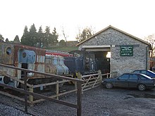 Stone building with steam railway engine outside it.