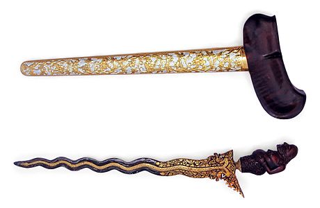 A decorative kris with a figure of Semar as the handle. The bilah has thirteen luk.