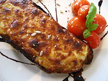 Photograph of a Welsh rarebit, melted cheese on toast.