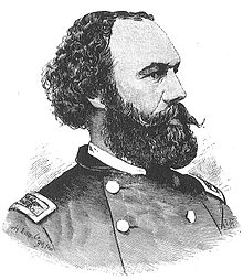 A black and white lithograph depicting a head and shoulders portrait of a United States Army officer of the Civil War era. He has curly black hair, a receding hairline and a large black mustache and beard. He is facing to the right and has a serious expression.