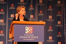 Photograph of Clinton speaking at a lectern to the College Democrats