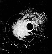 Black and white image showing areas of rainfall within the hurricane in white. The eye of the storm can be seen as a circular black region slightly right of center. The storm's rainbands can be seen wrapping around the eye.