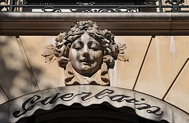Beaux Arts mascaron with flowers in its hair, above the door of the perfumery of Jacques and Pierre Guerlain
