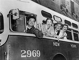 The cast hanging out of bus windows