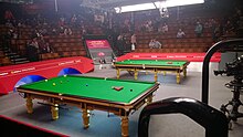 Photo of arena with two snooker tables