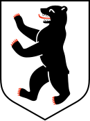 In einem nach unten spitz zulaufenden Wappenschild ist ein nach links stehender schwarzer Bär, dessen rote Tatzen und Zunge ausgestreckt sind.