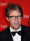A spectacled Jonathan Franzen is pictured in a tuxedo on a Time magazine red carpet. His short hair is somewhat untidy.