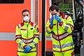 Mitarbeiter des Rettungsdienstes der Berufsfeuerwehr der Stadt Köln beim Anlegen von FFP-Masken zum Infektionsschutz