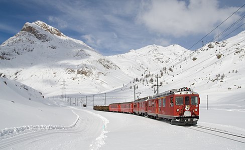 Die Berninabahn kurz vor dem Berninapass, im Hintergrund links der Piz Alv.