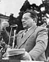 A black and white photo of Palmiro Togliatti giving a speech in front of a microphone