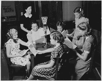 Six girls around a wooden table with a KTAR microphone. A woman supervises them.