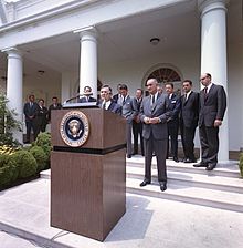 In this photo, David Rockefeller takes the podium as President Lyndon Johnson looks on in the White House Rose Garden on June 15, 1964, to announce the launch of the International Executive Service Corps.