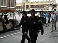 Two policemen (old patrol uniform) patrol Kraków's Old Market Square