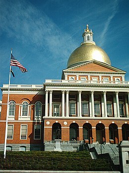 Large, domed building with columns and an American flag in front