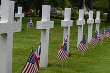 White grave markers with flags