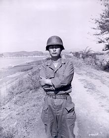 An Asian man in a military uniform in an outdoor setting
