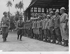 A Royal Navy officer inspecting the Japanese soldiers at the seaplane base at Gelugor