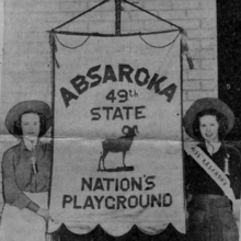 Ester Booras and Dorothy Fellows (Miss Absaroka) with the Absaroka State banner state 'the nation's playground'.