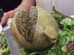 Haggis is a Scottish savoury pudding containing sheep's pluck (heart, liver, and lungs), minced with onion, oatmeal, suet, spices, and salt, mixed with stock, and cooked while traditionally encased in the animal's stomach.