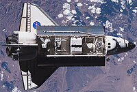 Space Shuttle Endeavour approaches the International Space Station during mission STS-118 with the S5 truss section ready to be installed.