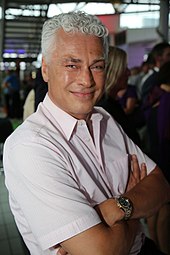 A man with white hair wearing a short sleeve shirt