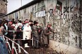 Mauerspechte brechen an der Mauer nahe dem Reichstagsgebäude Stücke heraus, Ende 1989