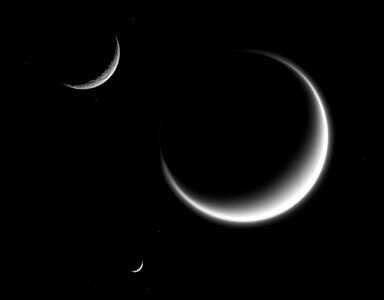 Titan (largest) together with Rhea and Mimas (smallest) in crescent shape, forming a triple crescent.[227] Titan's massive atmosphere is clearly seen extending out into space, while Rhea and Mimas have none.