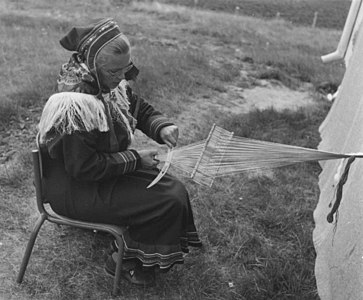 A Sámi weaver doing inkle weaving on a backstrap loom with a rigid heddle. Norway, 1956.