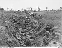 a black and white photograph of a trench with troops in it