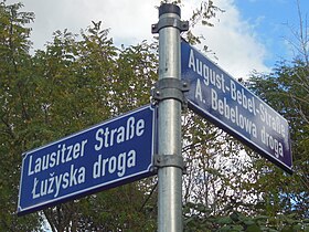 Zweisprachige Straßenbezeichnung auf Deutsch und Niedersorbisch