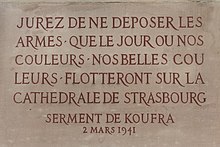 An inscription in stone, in French. It reads: "Jurez de ne déposer les armes que le jour où nos couleurs, nos belles couleurs flotteront sur la cathédrale de Strasbourg. 2 Mars 1941"