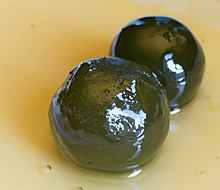 Two small round green fruit in syrup
