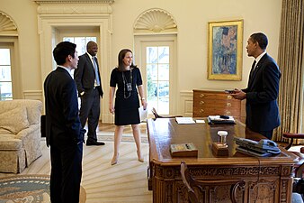 President Barack Obama jokes with Special Assistant Eugene Kang, Personal Secretary Katie Johnson and Personal Aide Reggie Love in the Oval Office.