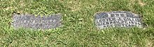 Two small gravestones recessed into the grass