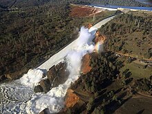 The image shows the Oroville Dam failing in February 2017.