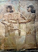 Assyrian attendants carrying the throne of Sargon II, part of a tributary scene from Khorsabad, Iraq. Iraq Museum