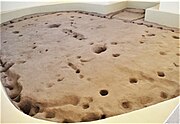 Sinagua pithouse, from 1050 CE. Two largest holes in the dirt floor held the timber roof supports. The holes around the edge reveal the outline of the structure.