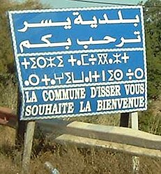 Dreisprachiges Straßenschild in Arabisch, Berberisch und Französisch „Die Stadt Isser heißt Sie herzlich willkommen!“